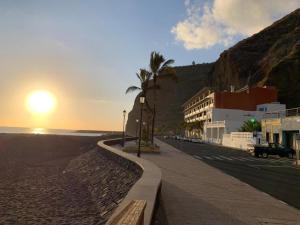 una acera junto a una playa con puesta de sol en Apartamento de dos dormitorios con Wifi y frente a playa en Puerto de Tazacorte en Tazacorte