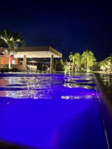 une piscine avec des lumières bleues en face d'un bâtiment dans l'établissement Île de Pipa com Hidromassagem, à Pipa