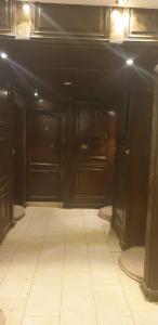 an empty kitchen with dark wood cabinets and a white tile floor at شقق للايجار اليومي المهندسين - الدقي -الزمالك in Cairo