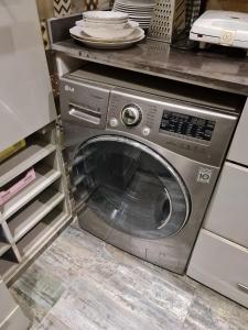 eine Waschmaschine in einer Küche mit Tellern drauf in der Unterkunft شقق للايجار اليومي المهندسين - الدقي -الزمالك in Kairo