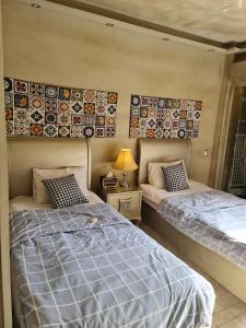 2 Betten in einem Zimmer mit Wandplatten in der Unterkunft شقق للايجار اليومي المهندسين - الدقي -الزمالك in Kairo