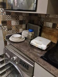 eine Küchentheke mit Tellern und einem Toaster darauf in der Unterkunft شقق للايجار اليومي المهندسين - الدقي -الزمالك in Kairo