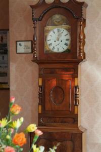 un reloj de abuelo está sentado en una pared en Saxonville Hotel, en Whitby