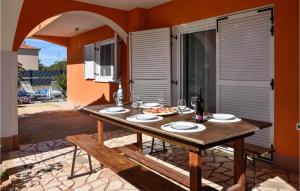 uma mesa com comida e uma garrafa de vinho num pátio em Gorgeous Home In Dugopolje With Kitchen em Kapela