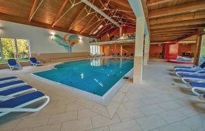 a large swimming pool with blue chairs in a building at Beautiful Home In St,georgen Am Kreischb, With 2 Bedrooms, Wifi And Indoor Swimming Pool in Sankt Lorenzen ob Murau