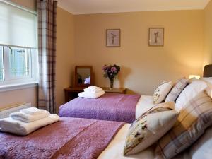 a bedroom with two beds and a mirror at Hillview in Beith