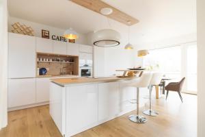 a kitchen with white cabinets and a table and chairs at Gästezimmer in Dresden mit Dach-Terrasse, Wohnbereich und Küche in Dresden