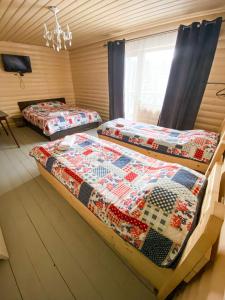 two beds sitting in a room with a window at Royal Yablunytsya in Yablunytsya