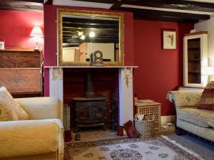 a living room with a fireplace and a mirror at Rebeccas Cottage in Ashby Saint Ledgers