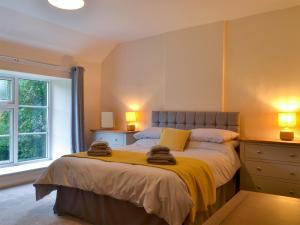 a bedroom with a bed with two towels on it at The Mill Cottage in Ault Hucknall