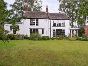 a white house with a yard in front of it at The Mill Cottage in Ault Hucknall