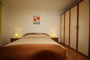 a bedroom with a bed and two lamps on two tables at Apartment Poropat in Poreč