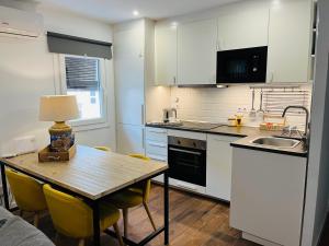 a kitchen with a table with chairs and a sink at Petit apartment LOS REMEDIOS in Seville