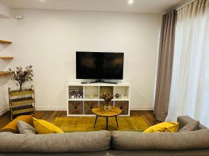 a living room with a couch and a flat screen tv at Petit apartment LOS REMEDIOS in Seville