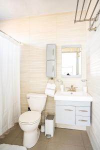 La salle de bains blanche est pourvue de toilettes et d'un lavabo. dans l'établissement Aquaville Dorado Moderna A Studio 7, à Dorado