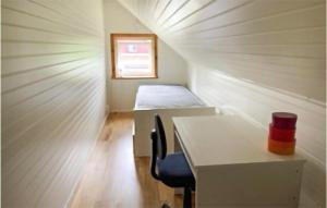 Cozy Home In Grythyttan With Kitchen في Grythyttan: غرفة صغيرة بها مكتب وسرير في غرفة