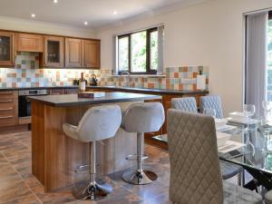 a kitchen with a bar with chairs and a table at Park Lane in Auldgirth