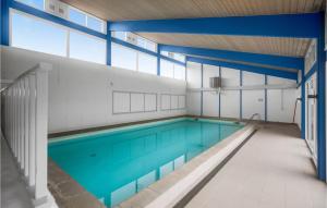uma piscina interior com água azul num edifício em Lovely Apartment In Nex With Sauna em Neksø
