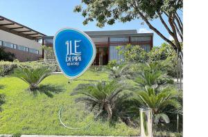 a blue sign in the grass in front of a building at Île de Pipa com Hidromassagem in Pipa