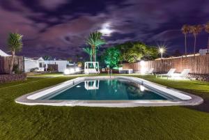 a swimming pool in a yard at night at VILLAS NEW LANZASUITES PLUS in Playa Blanca