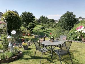 una mesa y sillas en un jardín con flores en Ferienwohnung Am Waldrand, en Bad Breisig