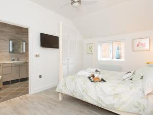a bedroom with a bed with a tray of food on it at Bay Cottage in Wereham