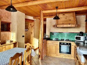a kitchen with a table and a stove top oven at Chalet Les Cocales Résidence Séjour et Nuitées B&B - Appartement Pin Sylvestre in Bessans