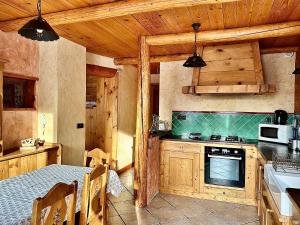 a kitchen with a table and a stove top oven at Chalet Les Cocales - Séjour et Nuitées - Appartement Pin Sylvestre in Bessans