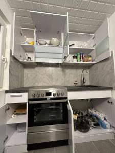 a kitchen with a stove and white cabinets at Mini Appartement neben Theater in Duisburg