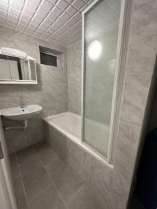 a bathroom with a tub and a sink and a shower at Mini Appartement neben Theater in Duisburg
