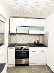 una cucina con armadietti bianchi e piano cottura di Mini Appartement neben Theater a Duisburg