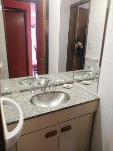 y baño con lavabo y espejo. en Amplio departamento en Nueva Cordoba - Bv Chacabuco en Córdoba