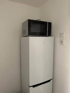 un forno a microonde seduto sopra un frigorifero di Mini Appartement neben Theater a Duisburg