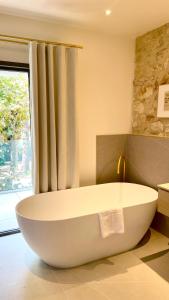 uma grande banheira branca na casa de banho com uma janela em La Maison Verchant em Montpellier