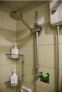 um chuveiro numa casa de banho com duas prateleiras na parede em WestParc Cedar Alabang em Manilla