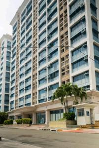 a large building with a palm tree in front of it at WestParc Cedar Alabang in Manila