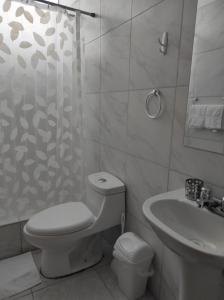 een witte badkamer met een toilet en een wastafel bij Runcu Arequipa in Arequipa