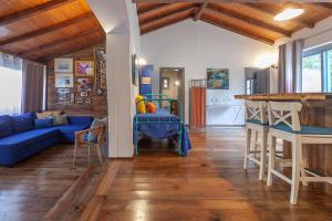 sala de estar con sofá azul y cocina en Vale da Silva Villas - Homes, en Albergaria-a-Velha
