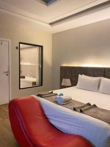 فندق جولدن توليب أبها - GOLDEN TULIP ABHA HOTEl في أبها: غرفة نوم بسرير كبير مع بطانية حمراء