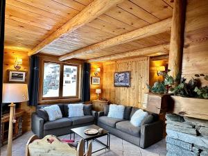 a living room with two couches and a stone fireplace at Chalet Les Cocales Résidence Séjour et Nuitées B&B - Appartement Pin Sylvestre in Bessans
