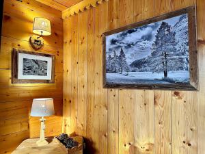 a room with a picture on a wooden wall with a lamp at Chalet Les Cocales - Séjour et Nuitées - Appartement Pin Sylvestre in Bessans +14 photos