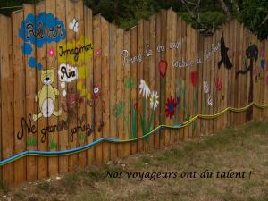 a fence with graffiti on it with a dog painted on it at maison d'art et d'autres in Champagne