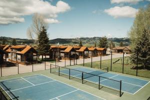 a tennis court with a net and some houses at Teton Valley Resort in Victor