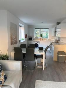 a kitchen and living room with a table and chairs at Ella Court Devon in Torquay