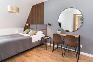a bedroom with a bed and a table and a mirror at Old Town Szczecin Black in Szczecin