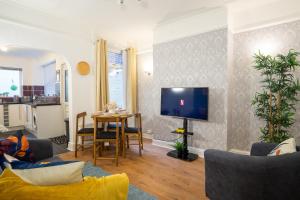 een woonkamer met een tafel en een televisie bij Air Host and Stay - Stanley Park House, 2 mins from LFC, sleeps 7 in Liverpool