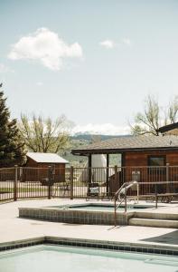 a swimming pool with a fence and a house at Teton Valley Resort in Victor
