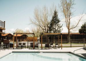 a swimming pool with a gazebo and a house at Teton Valley Resort in Victor