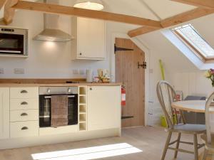 a kitchen with a stove and a table in a room at The Hay Barn - Ukc4135 in Arlingham