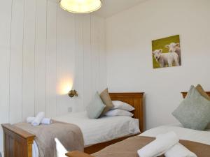 a room with two beds and a picture on the wall at The Hay Barn - Ukc4135 in Arlingham